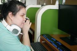 young blind person woman with headphone using smart phone with voice-assistive technology