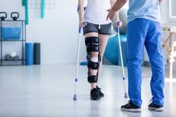 professional physiotherapist supporting patient with orthopedic need