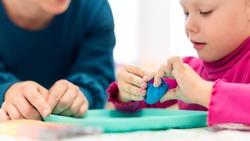 toddler girl in child occupational therapy session doing sensory playful exercises